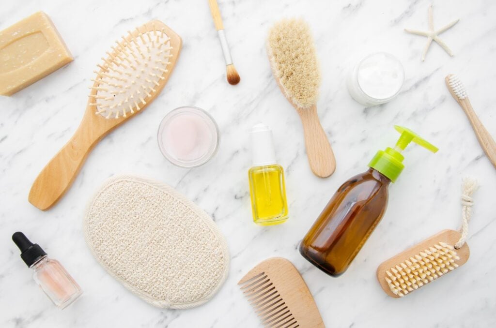 Hair products and tools against a marble background.