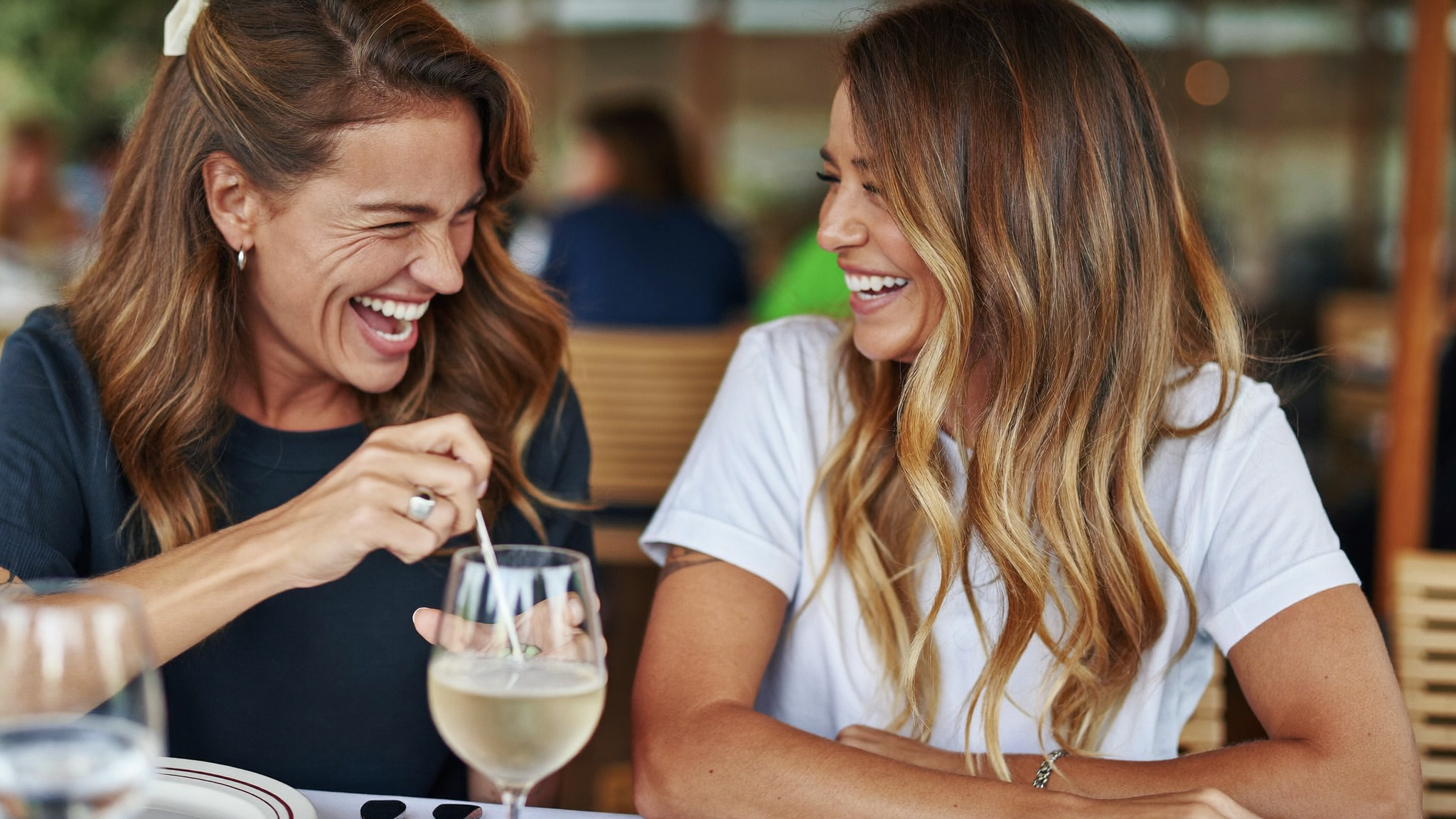 Two women laughing together at a cafe