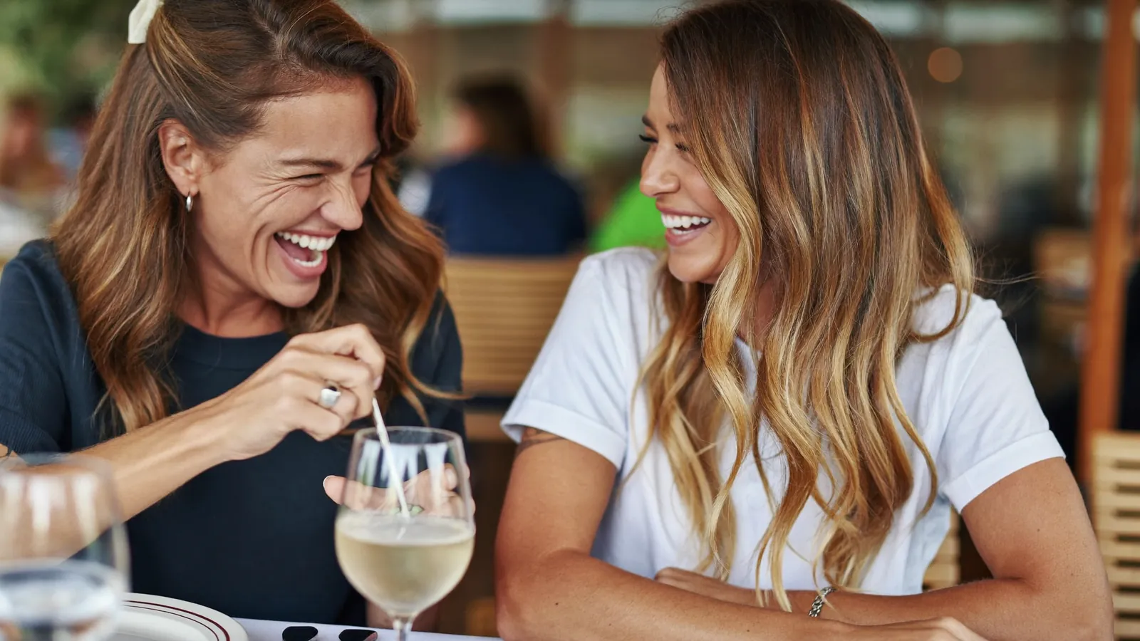 Two women laughing together at a cafe