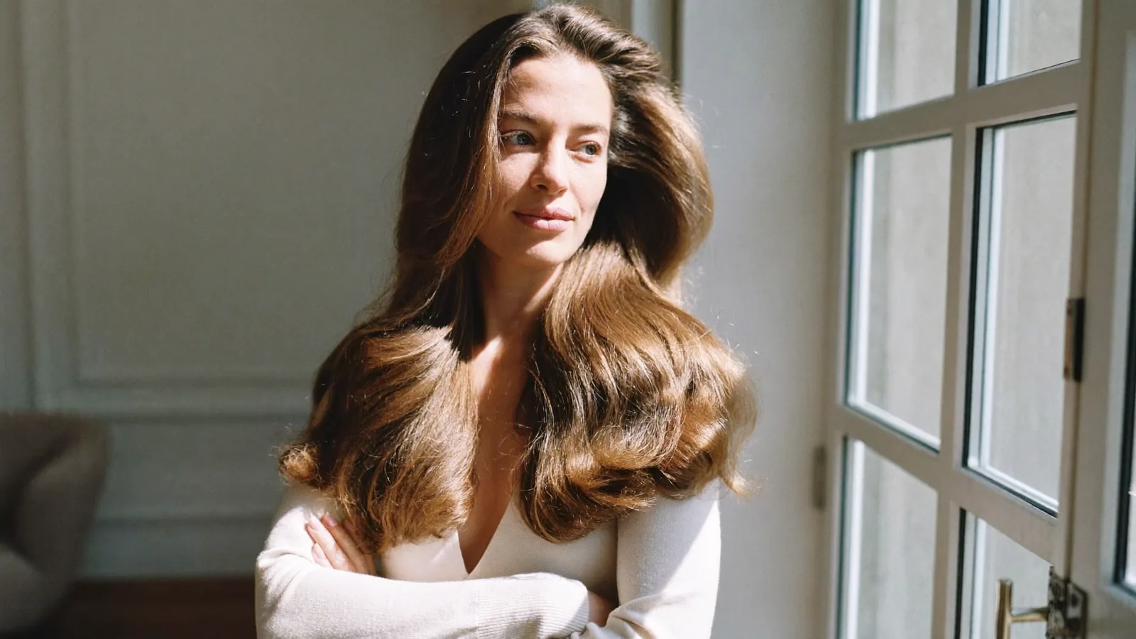 Woman with natural-looking hair by a window