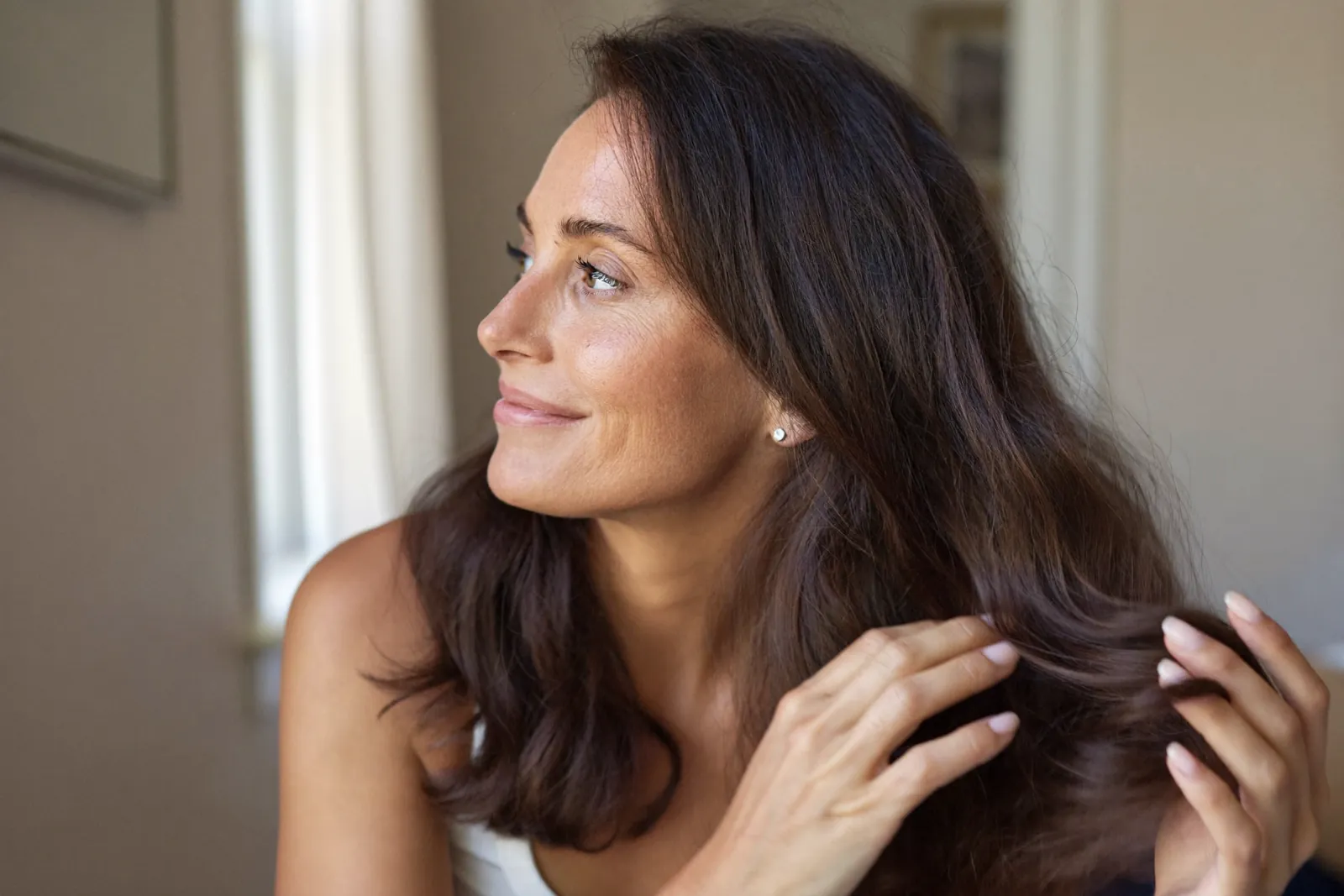 Woman gently touching her dark hair