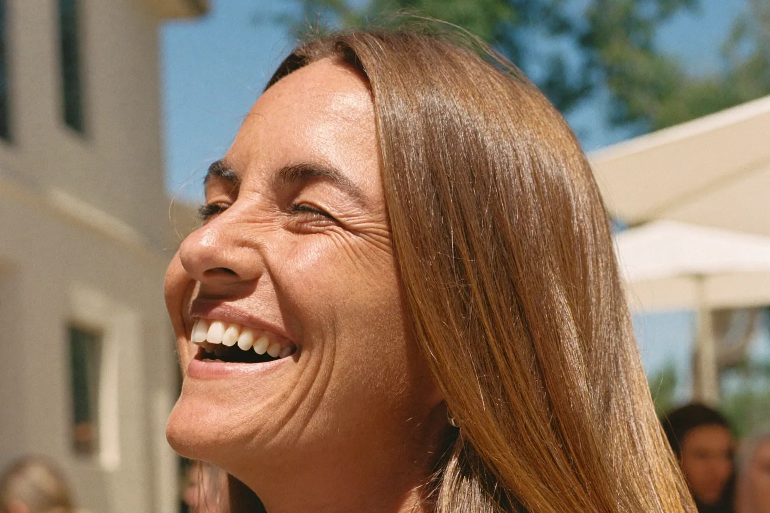 Woman laughing outdoors in the sun