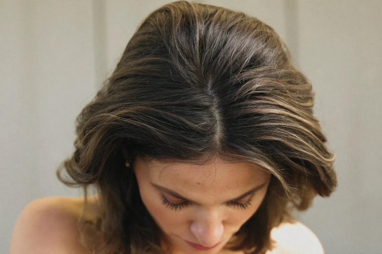 Woman looking down showing thinning at the crown and part