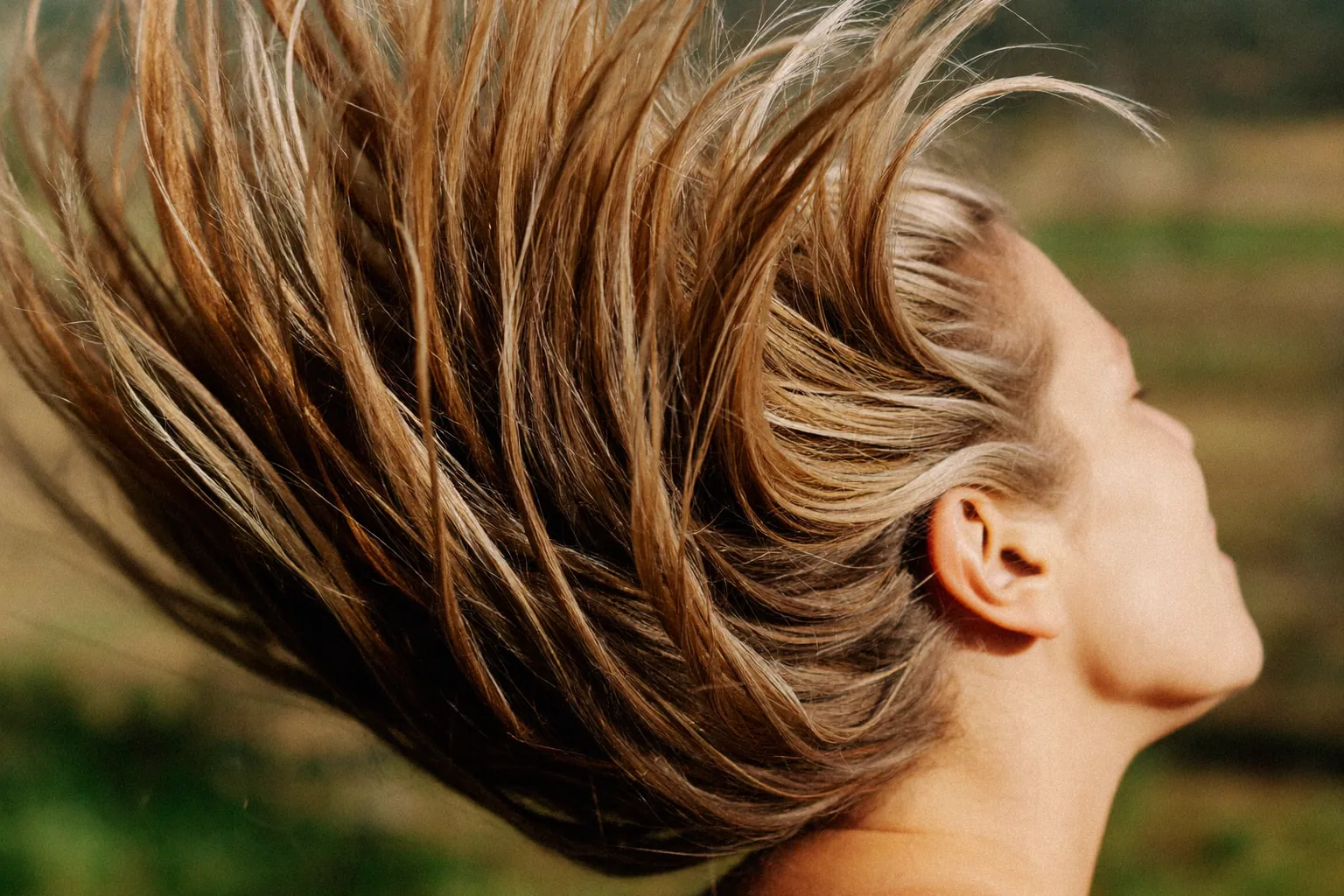 Woman outdoors with hair blowing back