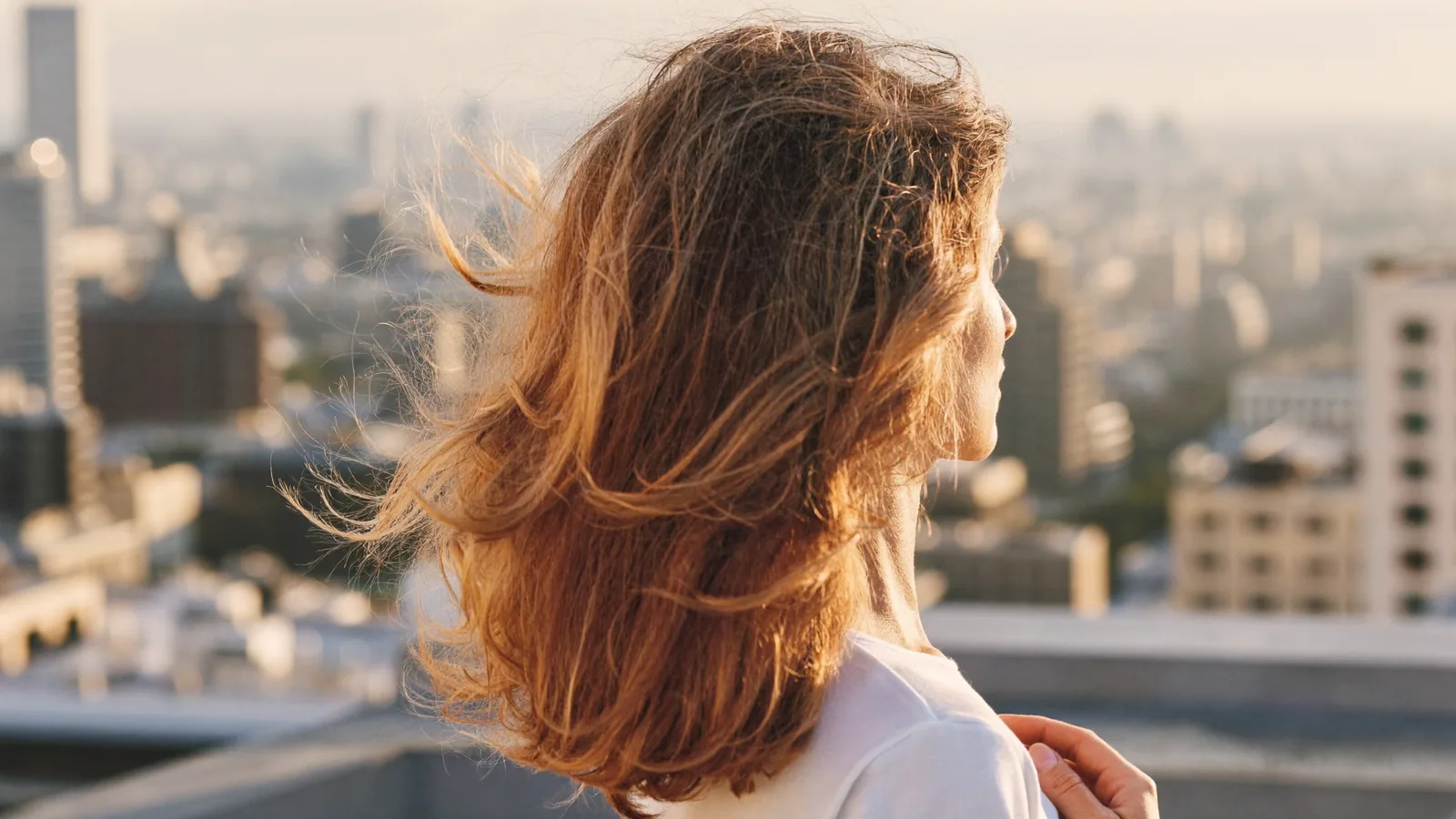 Woman with natural-looking hair on a city rooftop