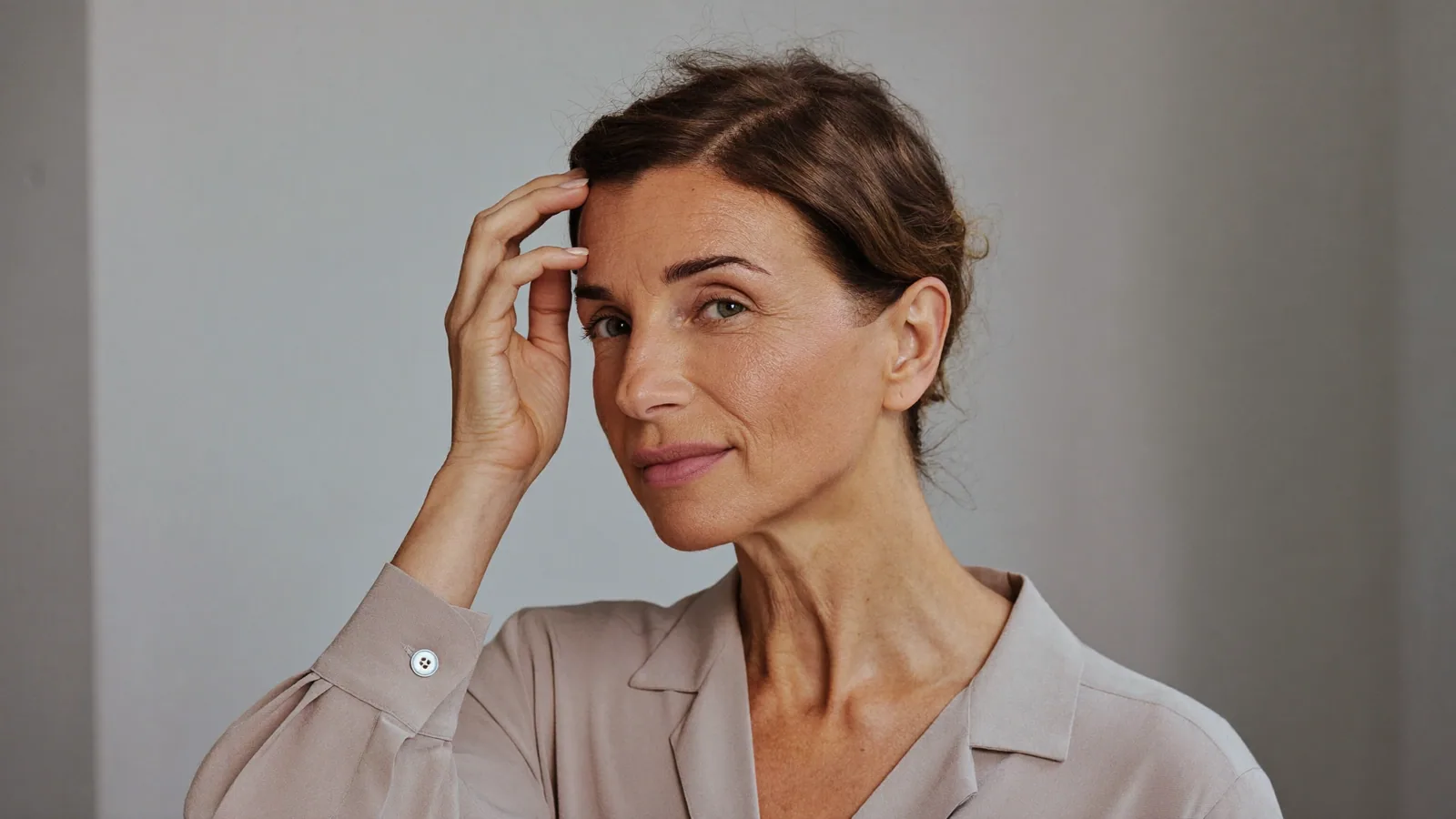 Woman touching her hairline thoughtfully