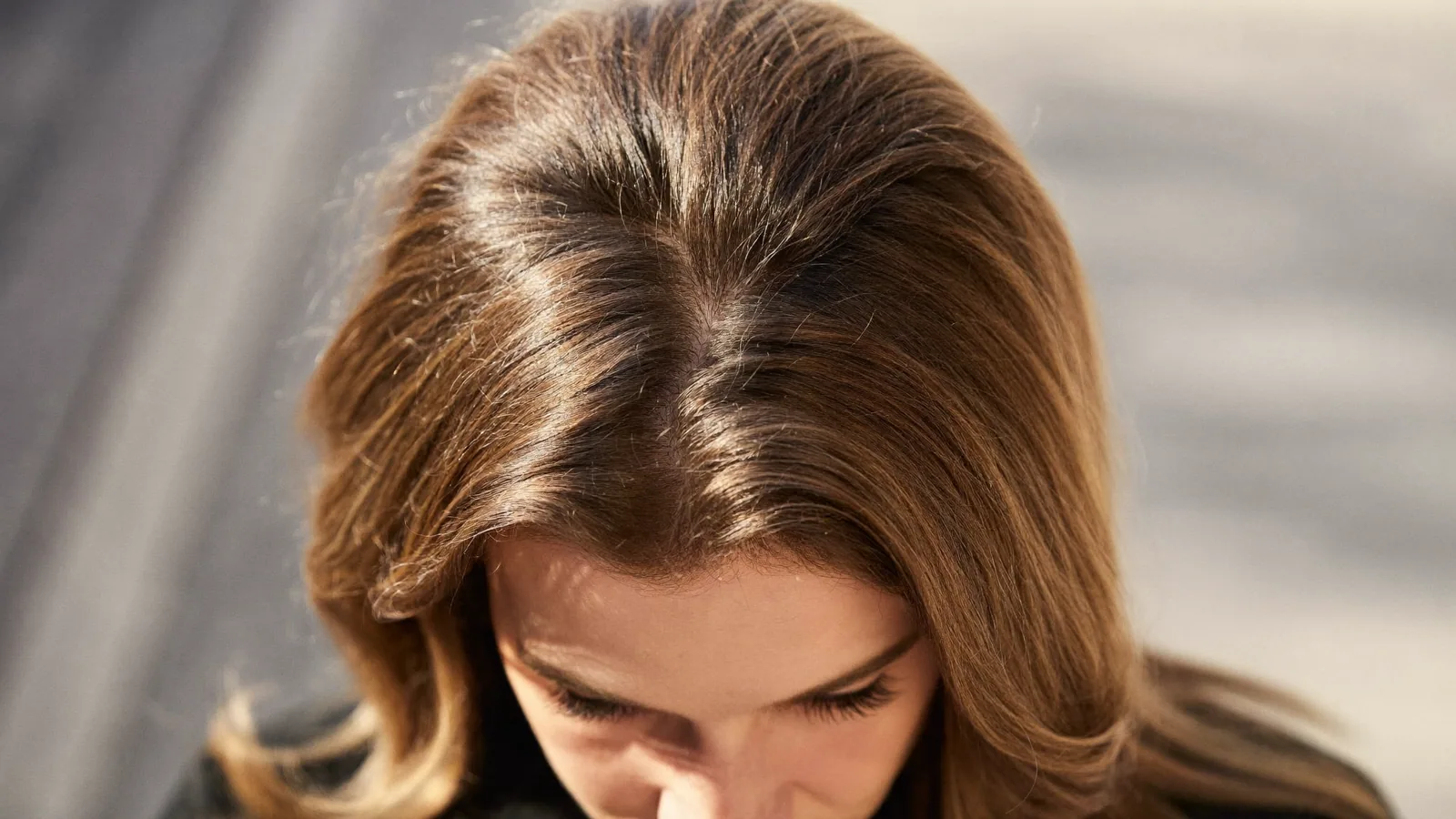 Woman with sunlit hair looking down
