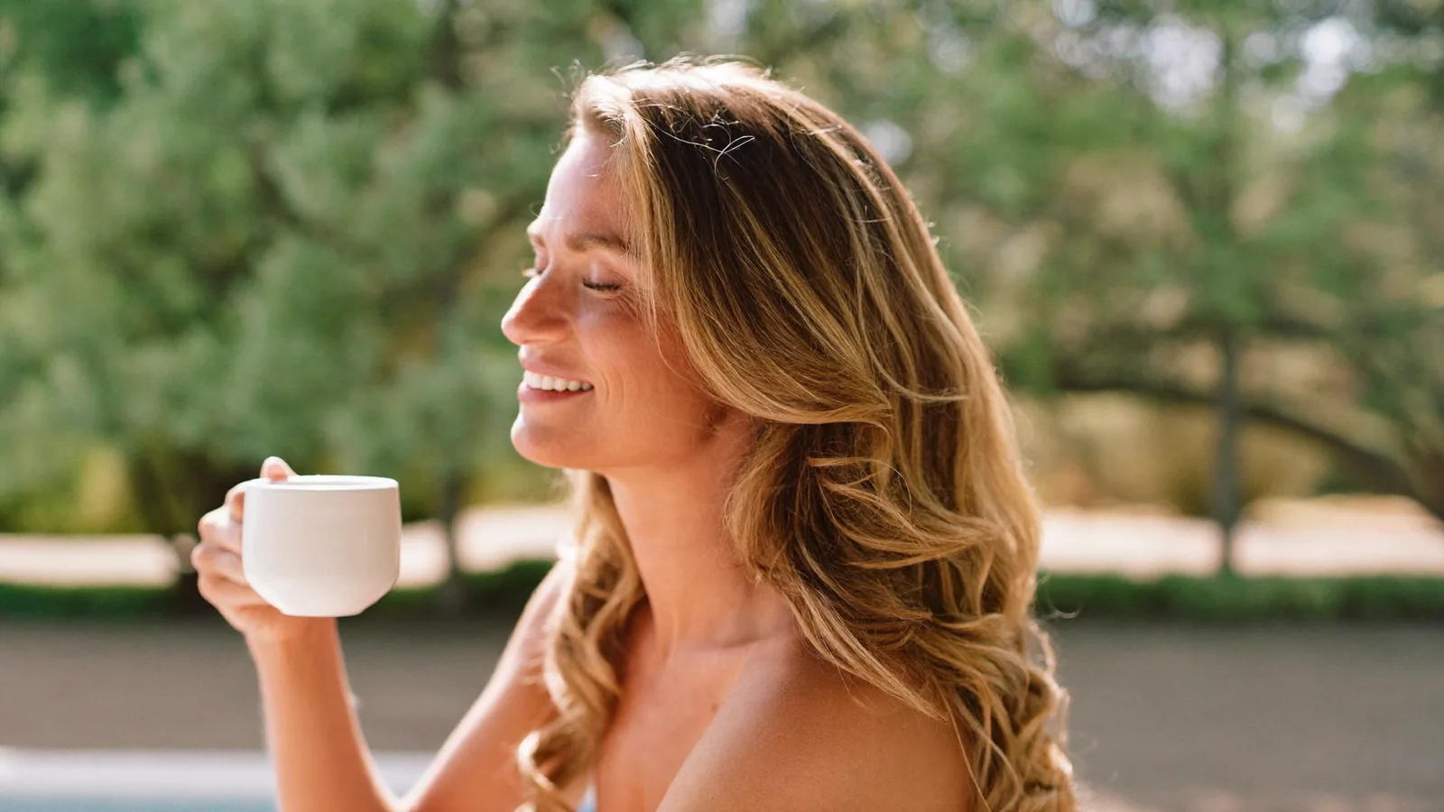 Woman smiling with coffee outdoors