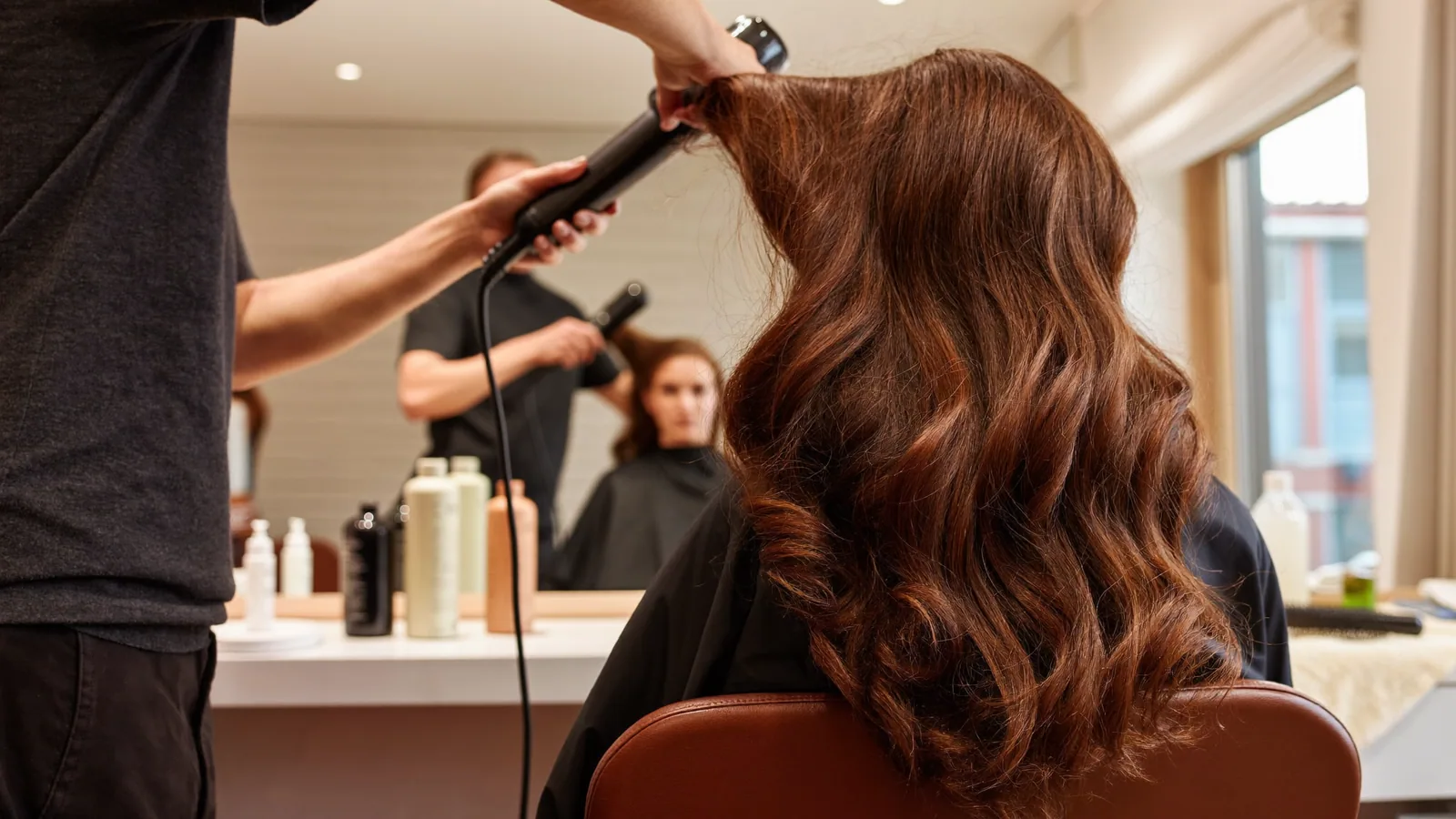 Stylist styling a client's hair in the salon